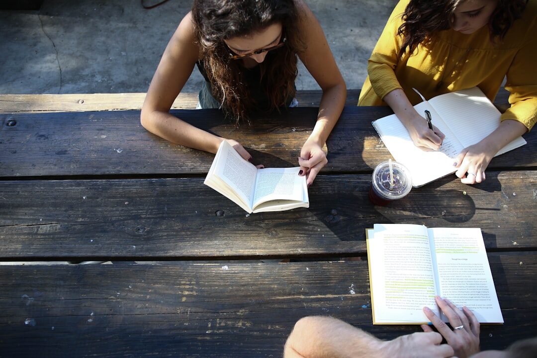 Small group of people collaborating around a table with notes and books